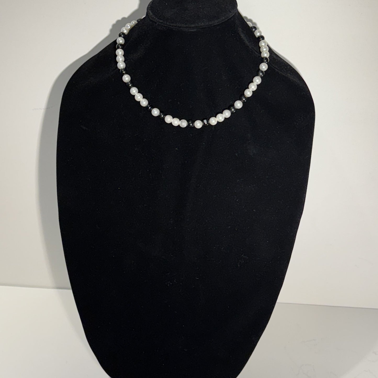 “Where classic pearls meet bold contrast.”