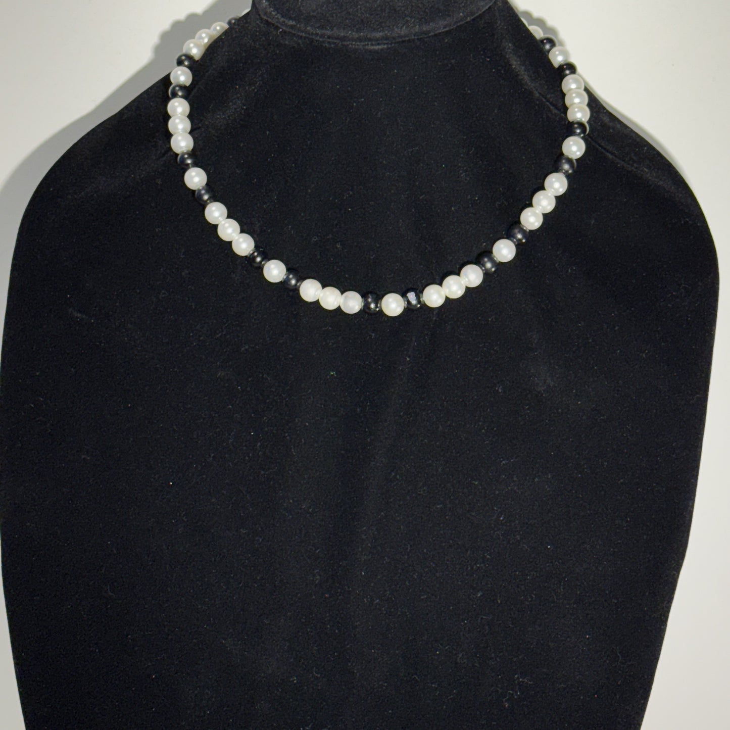 “Where classic pearls meet bold contrast.”