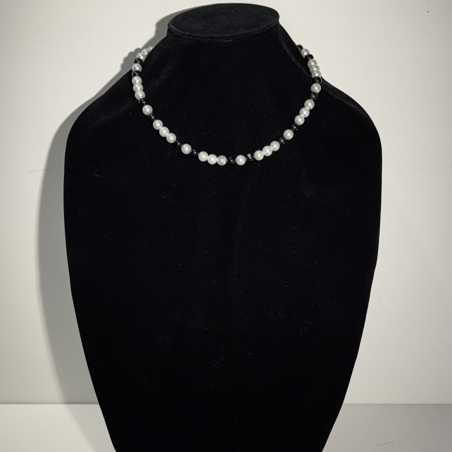 “Where classic pearls meet bold contrast.”