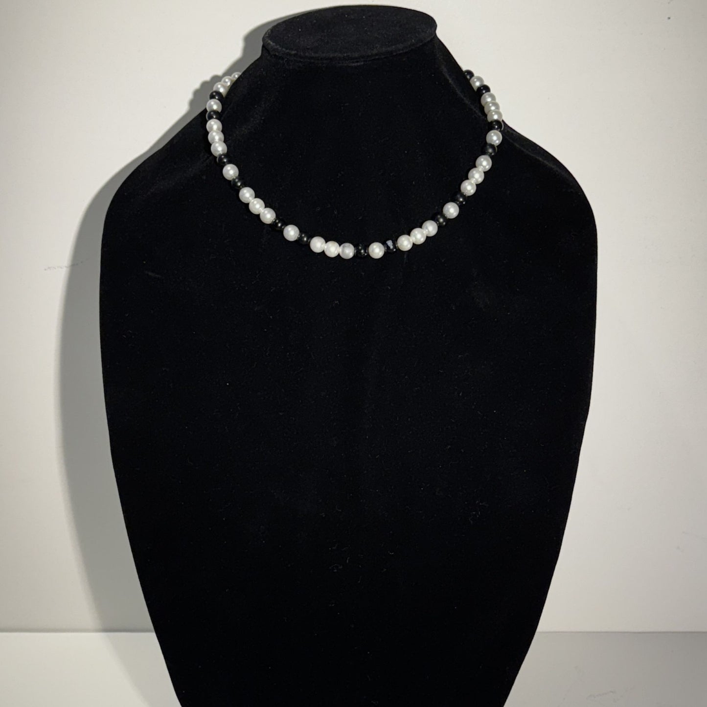 “Where classic pearls meet bold contrast.”